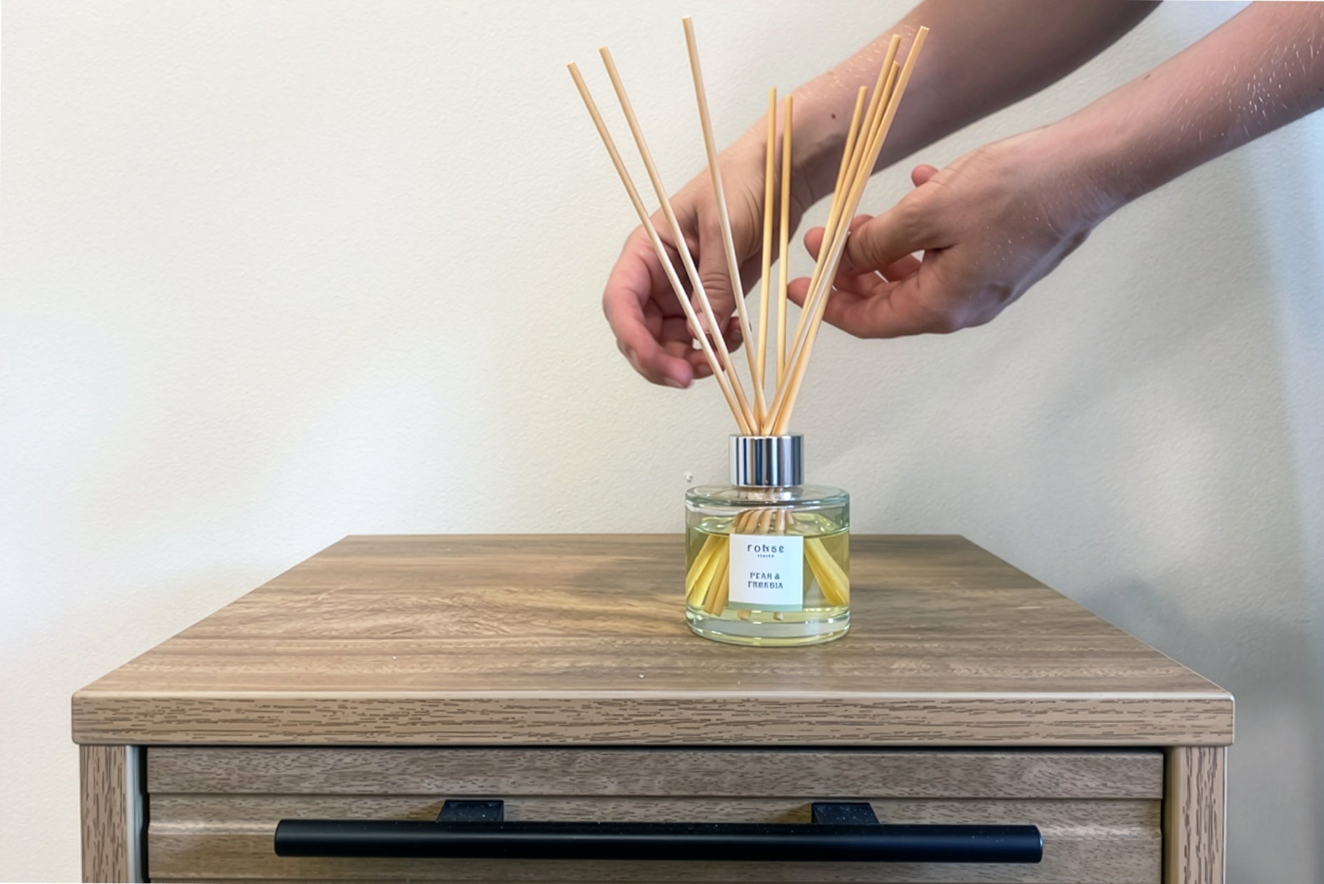 flipping the reeds on a reed diffuser to refresh the scent