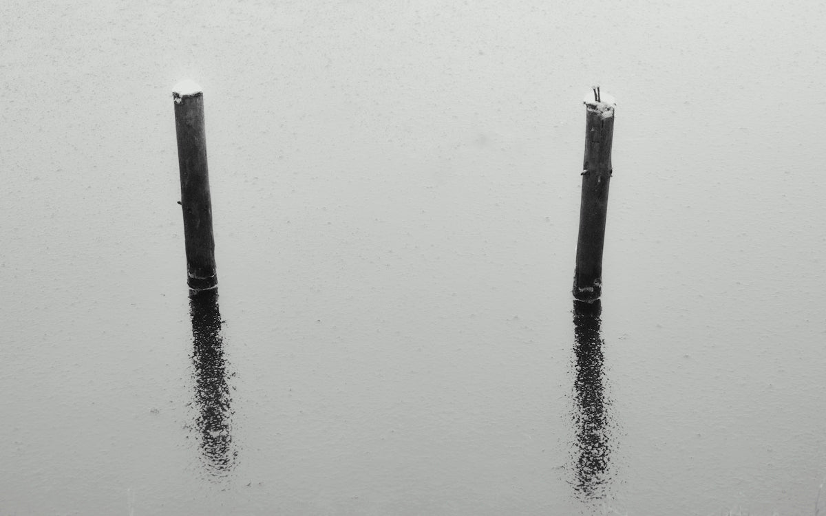 two poles sticking out of the water in the rain