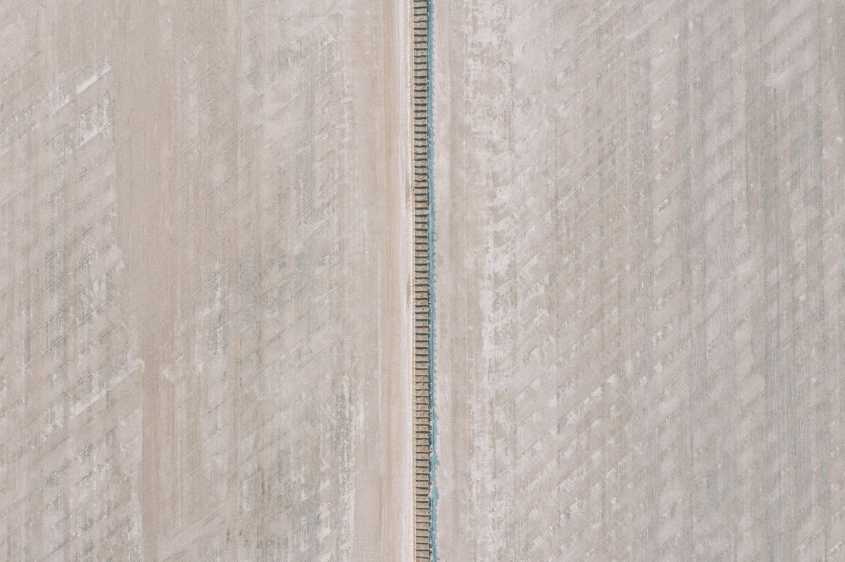 an aerial view of a road in the middle of a field