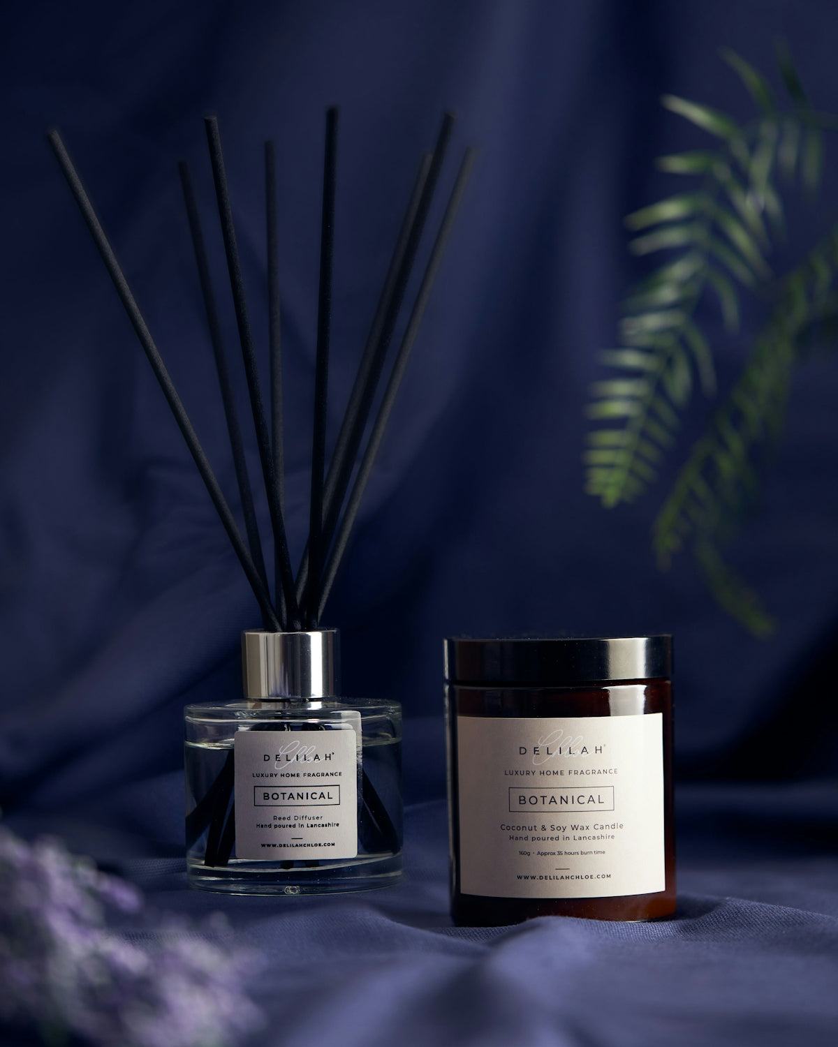 a couple of glass jars with brown liquid and a plant in the background