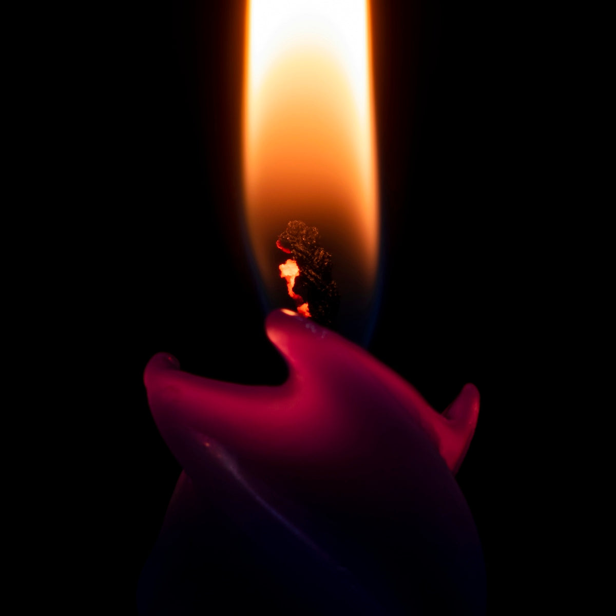 a candle with a candle holder in the middle of it