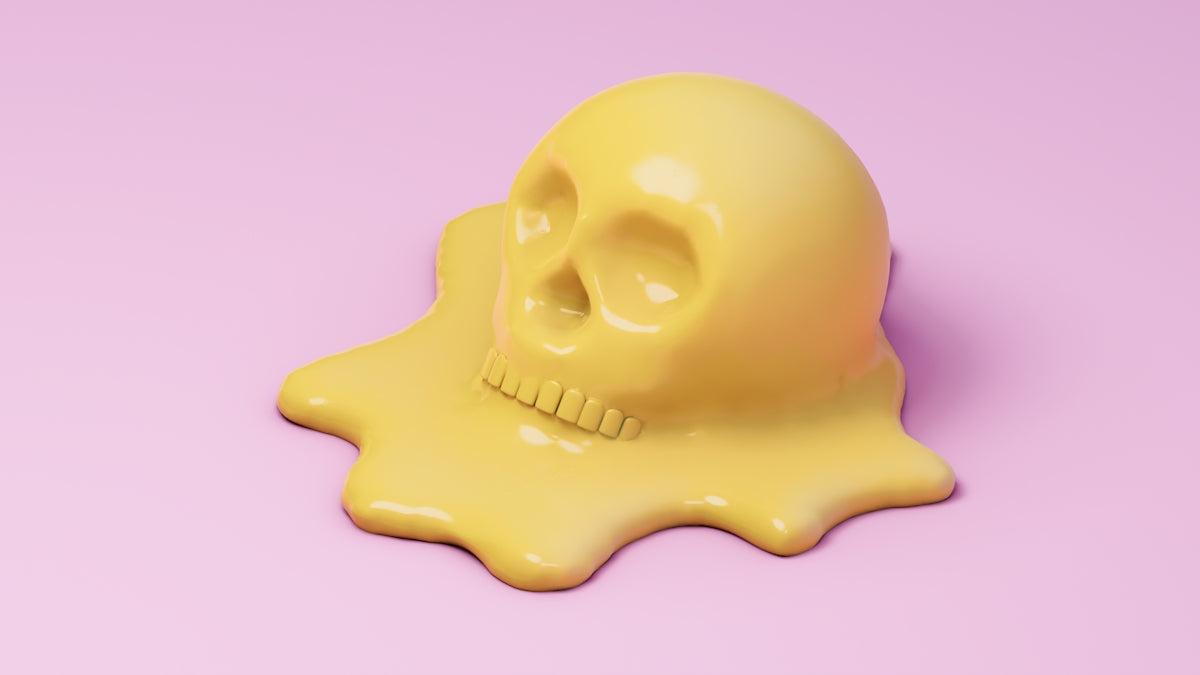 A yellow skull is melting on a pink surface.