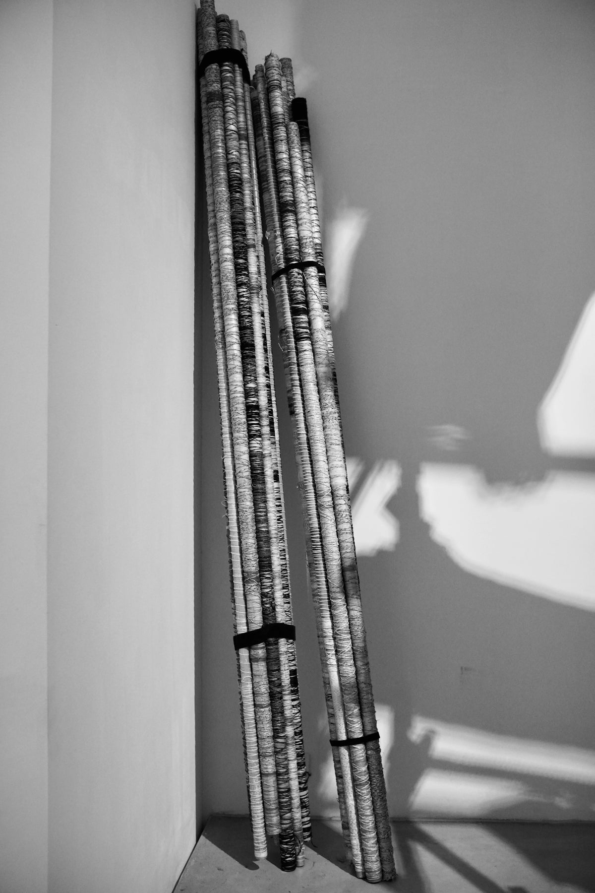 Bundled rolled papers leaning against a wall