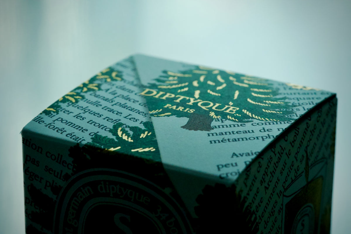 Diptyque paris product packaging with gold lettering.