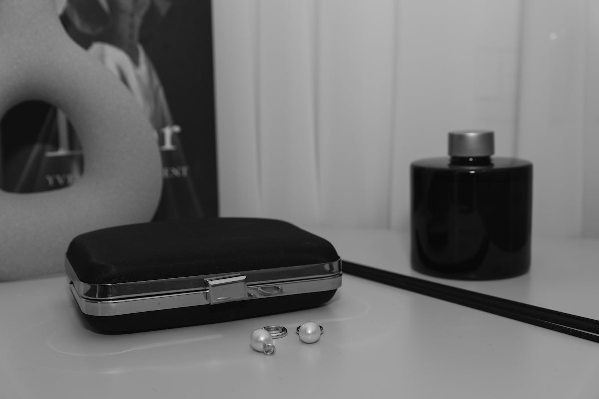 Clutch purse with jewelry and diffuser on table