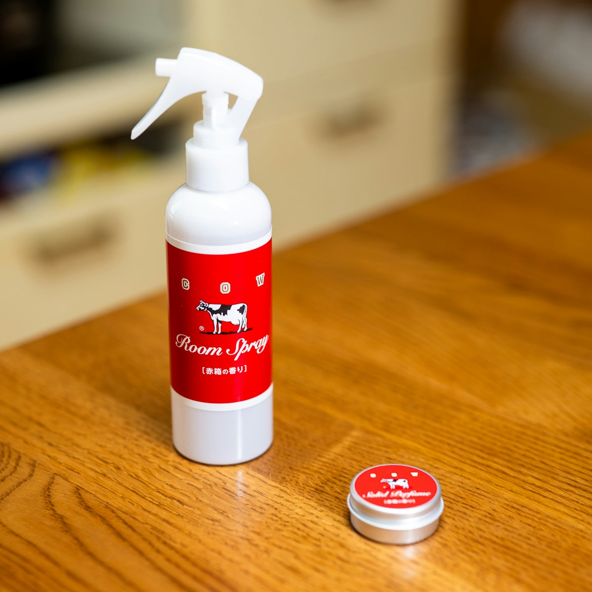 White spray bottle and small tin on wooden table