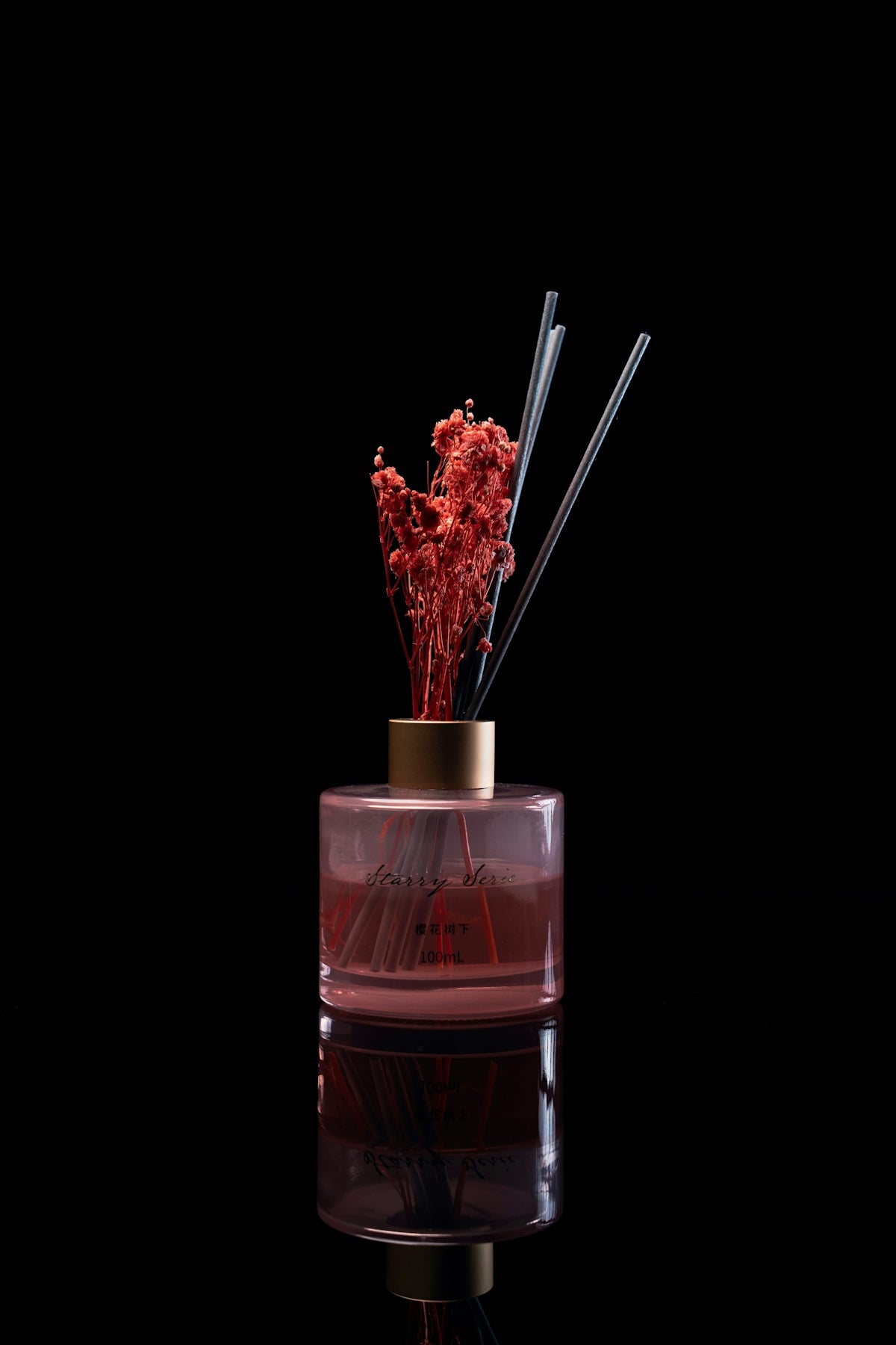 Reed diffuser with dried flowers on black background