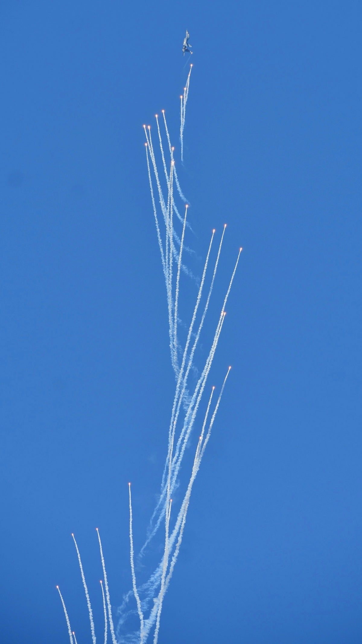 An airplane is flying in the blue sky