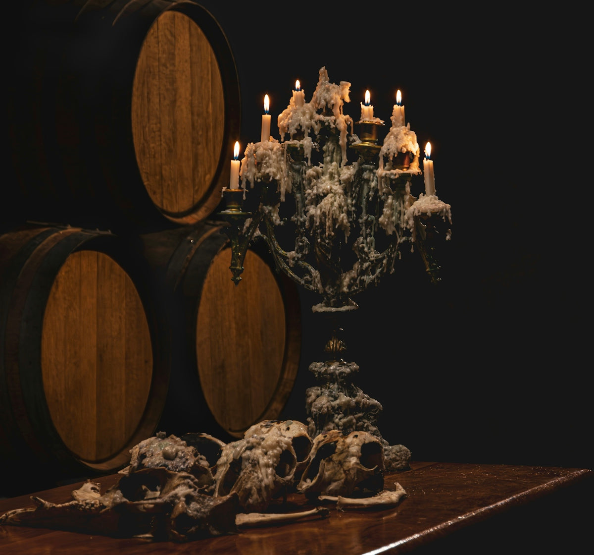 Candles on a candelabra with animal skulls and barrels.