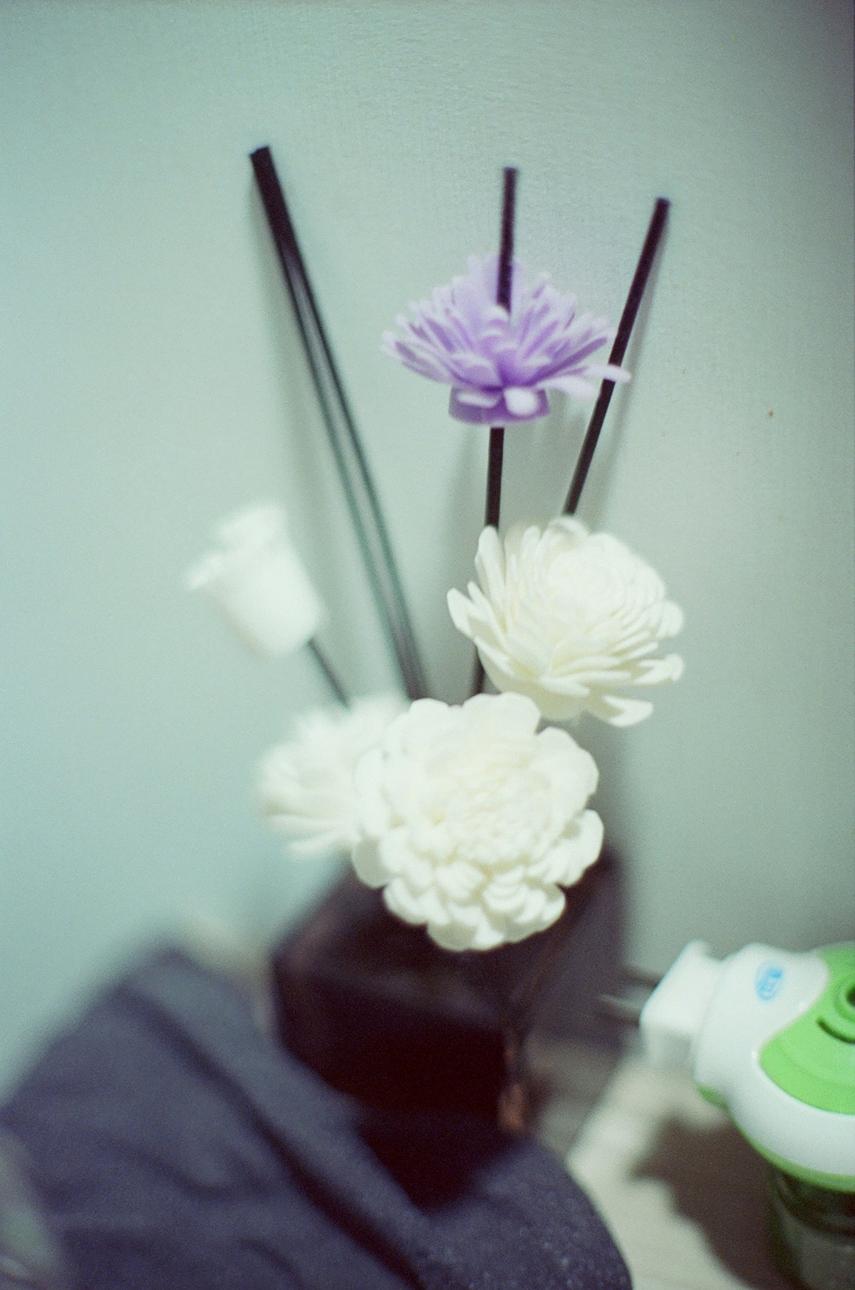 Reed diffuser with white and purple flowers.