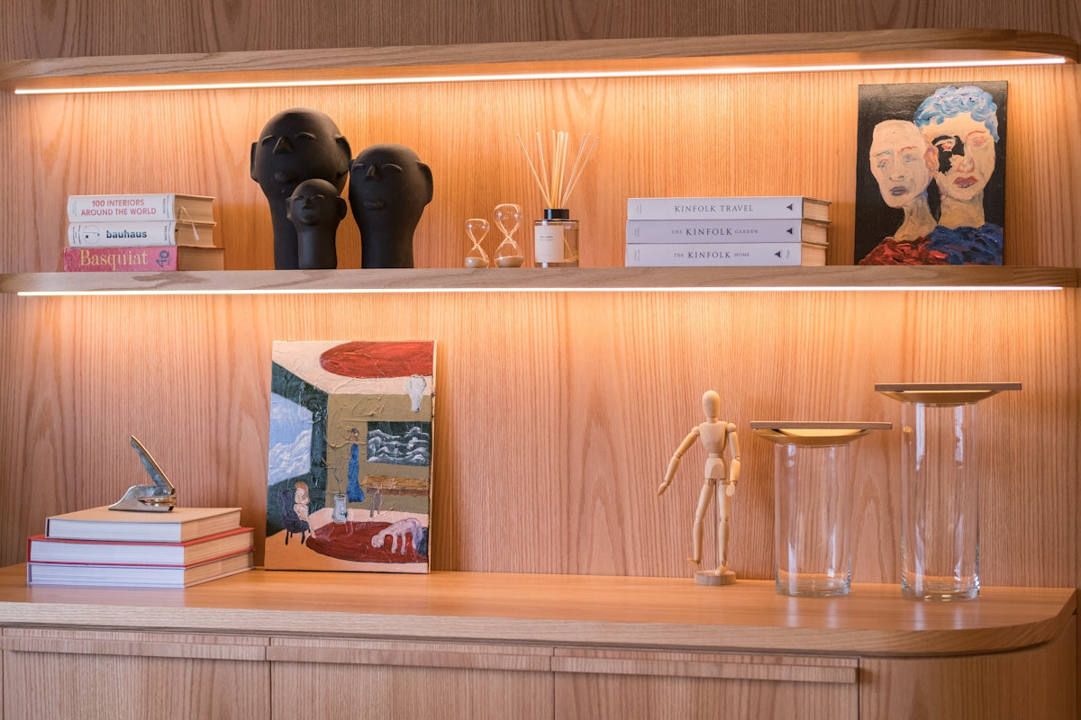 Decorated shelves with books, art, and sculptures.